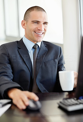 Middle aged business man with a coffee cup while using computer