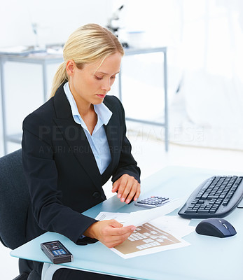 Young business woman sitting at office desk and reading a document