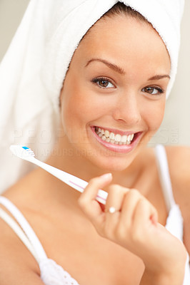 Smiling young woman with healthy teeth holding a toothbrush