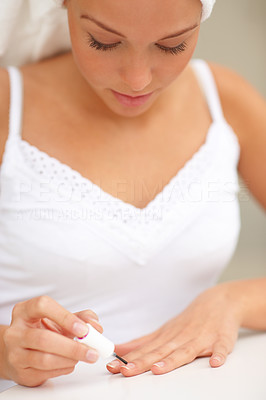 Closeup portrait of cute young female polishing nails