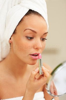 Portrait of a beautiful woman getting ready applying lipstick