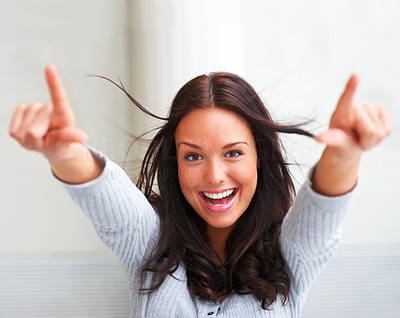 Portrait of excited young female pointing with both hands towards the camera