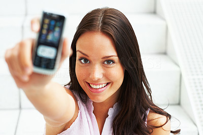 Beautiful girl showing her mobile over white background
