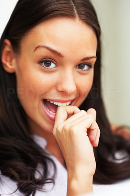 Closeup of beautiful lady biting her finger and smiling