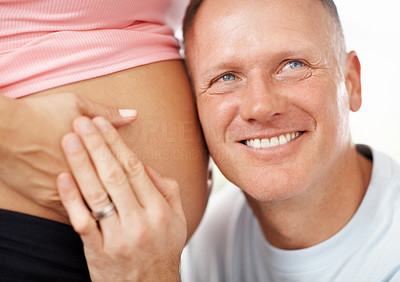 Happy man listening to his wife\'s belly
