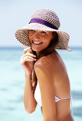 Cute woman in hat at the beach smiling