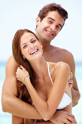 Young couple hugging and smiling at the beach