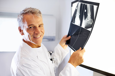 Smiling male radiologist examines x-ray