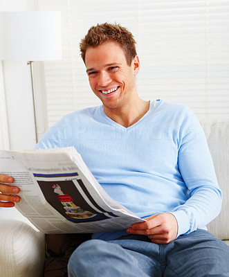 Modern life - young man laughing and reading newspaper