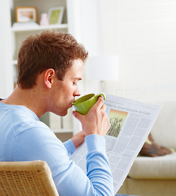 Man drinking coffee and reading newspaper