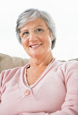 Closeup portrait of a sweet retired woman sitting on a couch