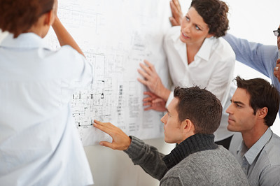 Business colleagues studying a chart displayed on the wall