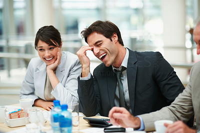 Business colleagues enjoying a laugh at a meeting
