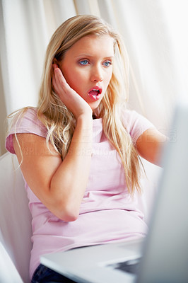 Shocked woman looking at the screen on her laptop