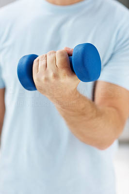 Mid section of a healthy guy using a dumbbell