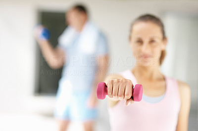Blur image of a female working out with a dumbbell at the gym