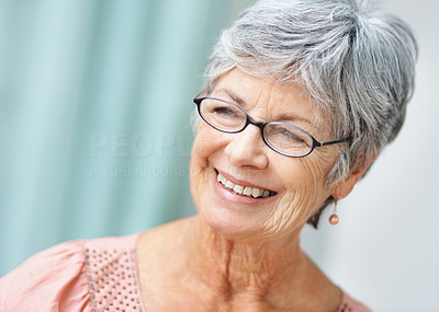 Closeup portrait of a pretty senior lady smiling in thought