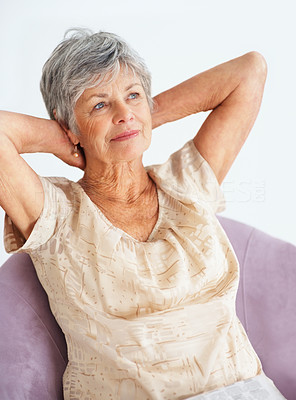 Thoughtful elderly woman with hands behind head