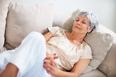Elderly woman lying with eyes closed on couch