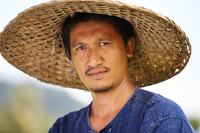 Portrait of a rice farmer in Thailand wearing a traditional hat