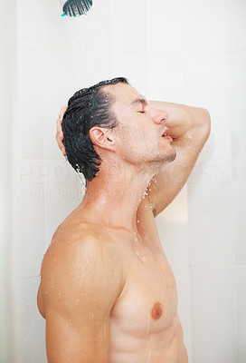 Muscular man washing his hair