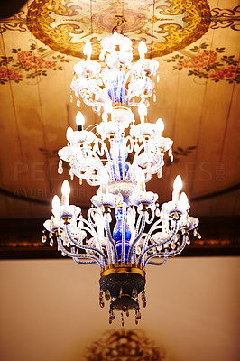 Ornate chandelier hanging from a decorated ceiling