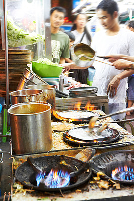 Chefs at a Thai streetmarket preparing food
