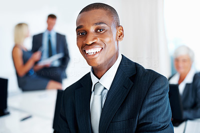 African American business man smiling with colleagues in background