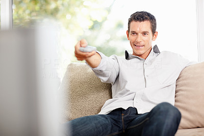 Middle aged man with remote control changing channel