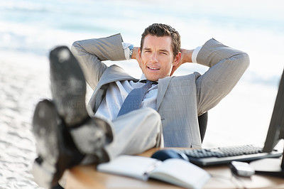 Relaxed middle aged business man with his legs on desk