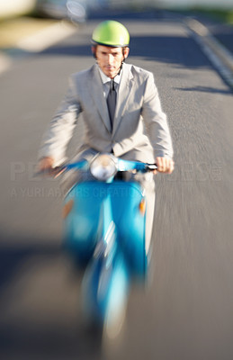 Blurred motion of a business manager riding a scooter