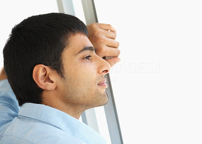 Profile view of a young man lost in thought indoors