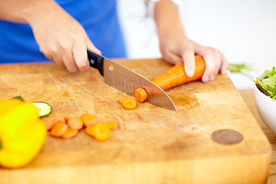 Cropped view of a woman\'s hands chopping vegetables in meal preparation