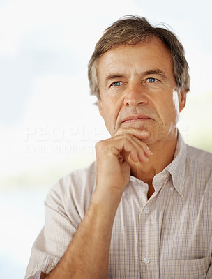 Thoughtful elderly man with hand on chin