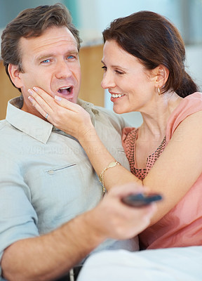 Man ignoring woman while watching TV