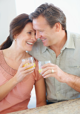 A romantic mature couple with juice glasses at a table