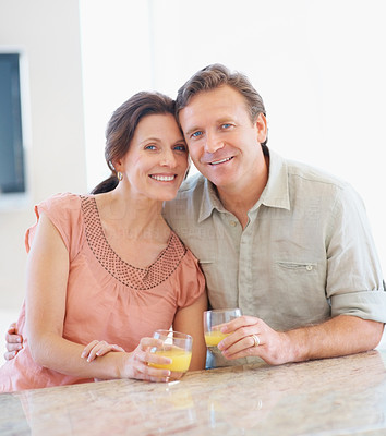 Portrait of a mature couple with juice glasses at a table
