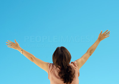 Rear view of a woman spreading arms to sky