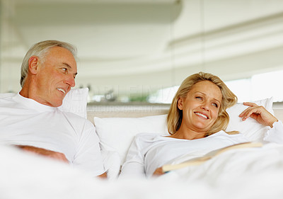 Smiling couple relaxing in bed at home