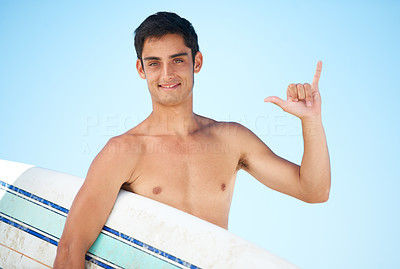 Portrait of a young topless surfer holding his surfboard with the blue sky behind him