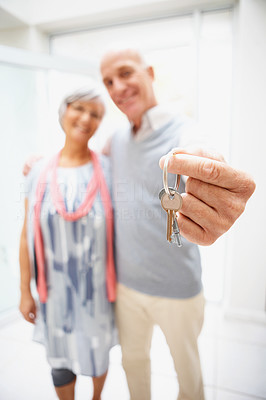 Happy senior happy couple with keys to their new home