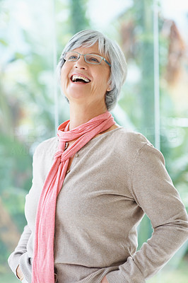 Portrait of happy senior woman laughing over bright background