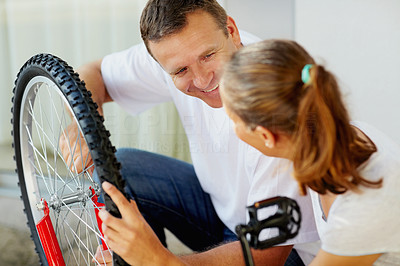 Happy man repairing a bicycle tyre for wife