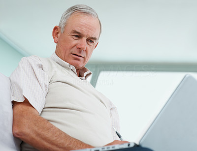 Confused senior man working on a laptop