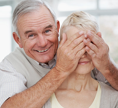 Closeup of an elderly man covering wife\'s eyes