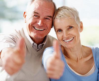 Smiling senior couple showing a success sign
