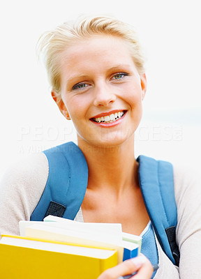 Happy pretty female student holding books , outdoors