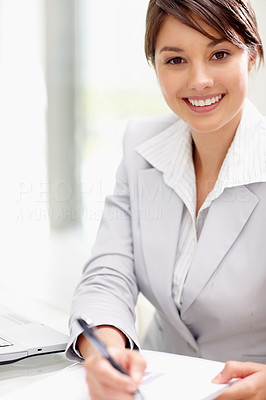 Lovely young business woman making notes while at the work