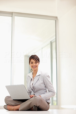 Lovely business woman using a laptop , sitting on the floor
