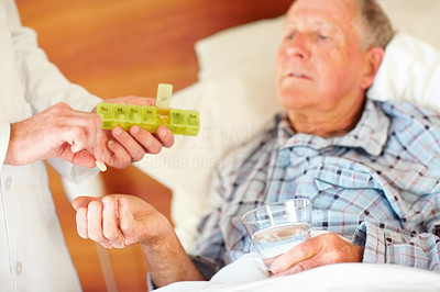 Senior citizen being given a pill by doctor